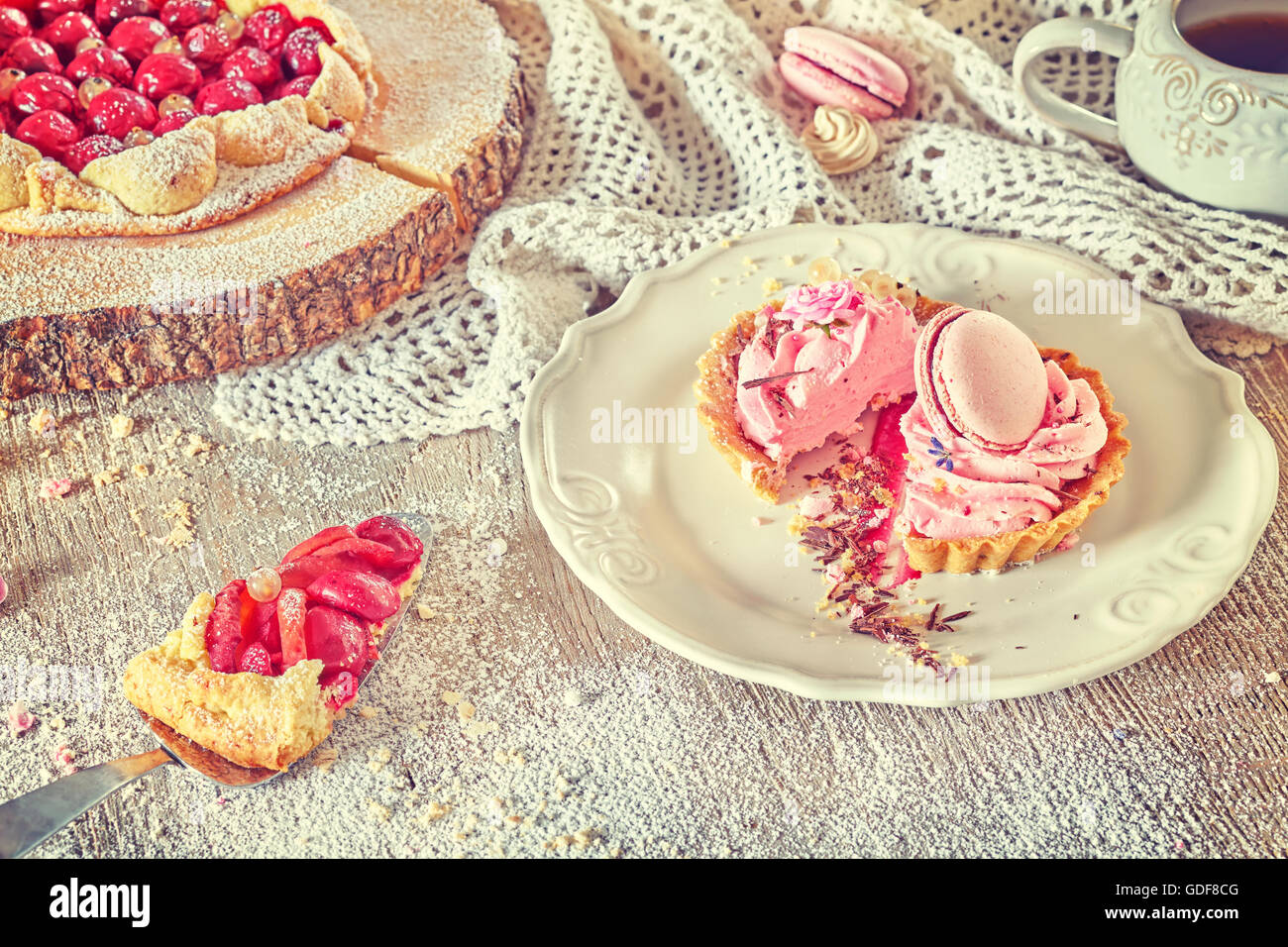 Retro toned rustic set of fruit tarts and meringues, homemade pastry, pastel colors. Stock Photo