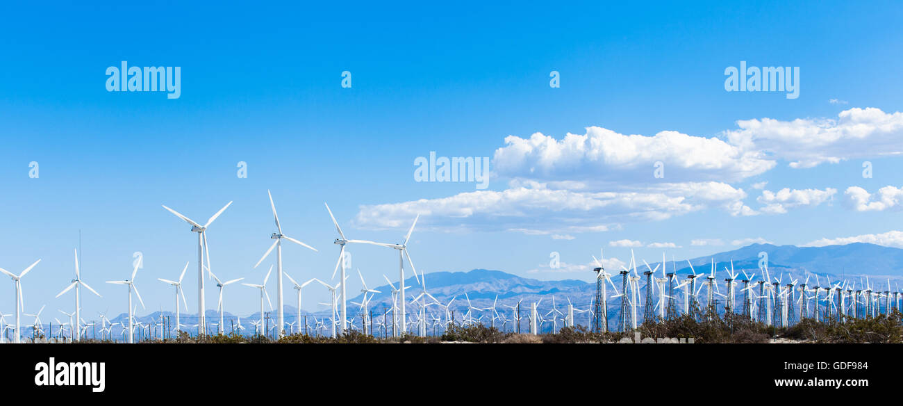 Horizontal scenic shot of a field of wind turbines against a blue sky ...