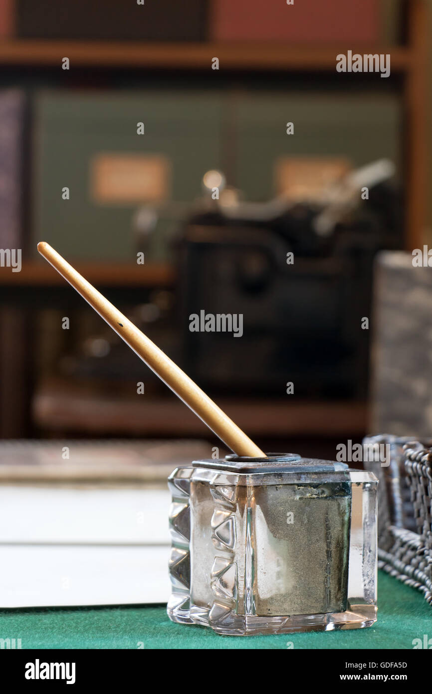 old glass inkwell with a pen on the table Stock Photo Alamy