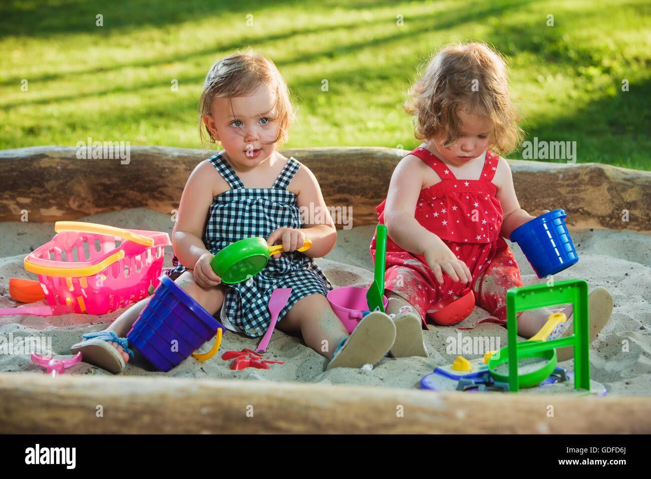 The two little baby girls playing toys in sand Stock Photo - Alamy