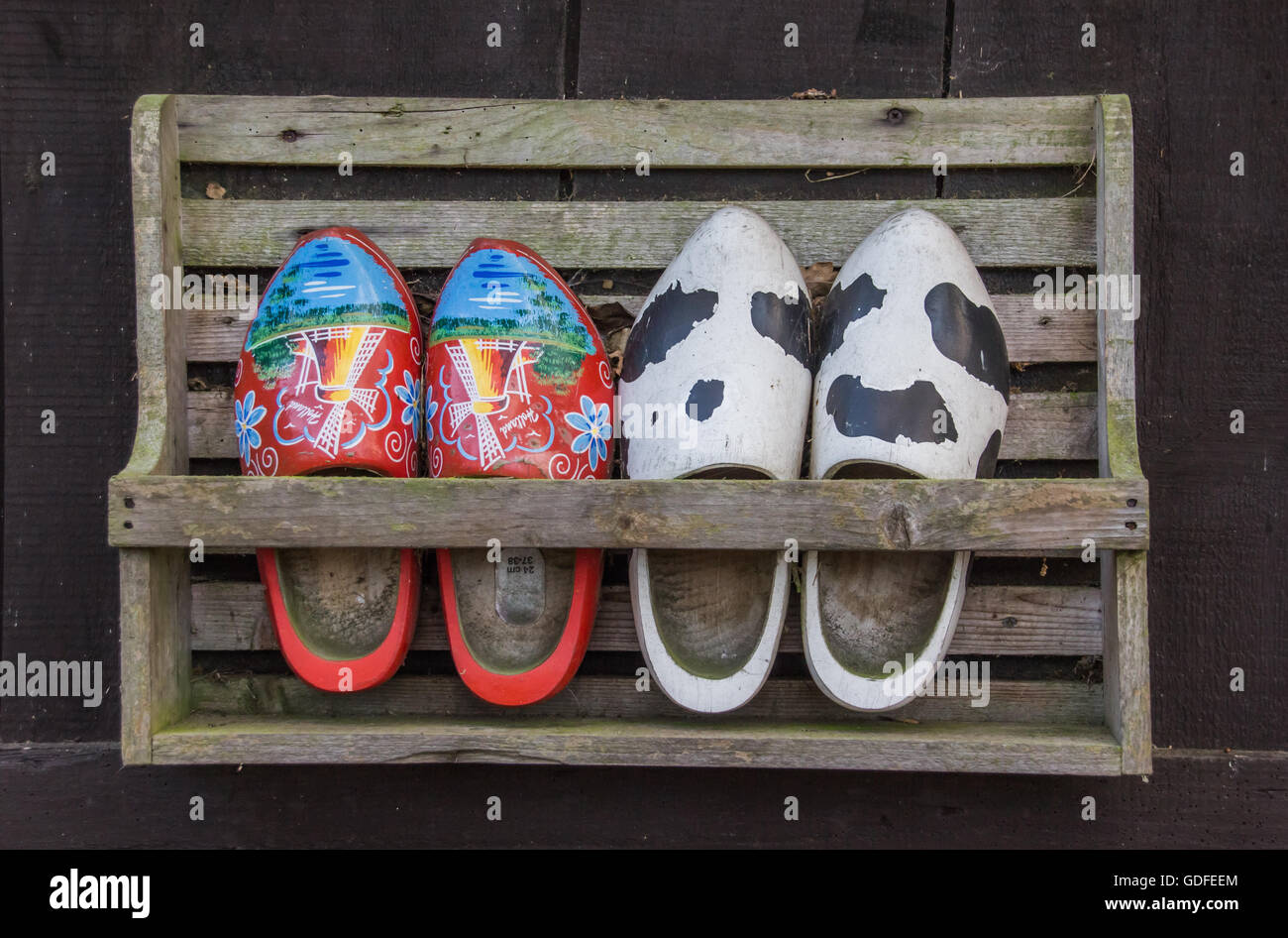 Two pairs of wooden shoes in a rack Stock Photo