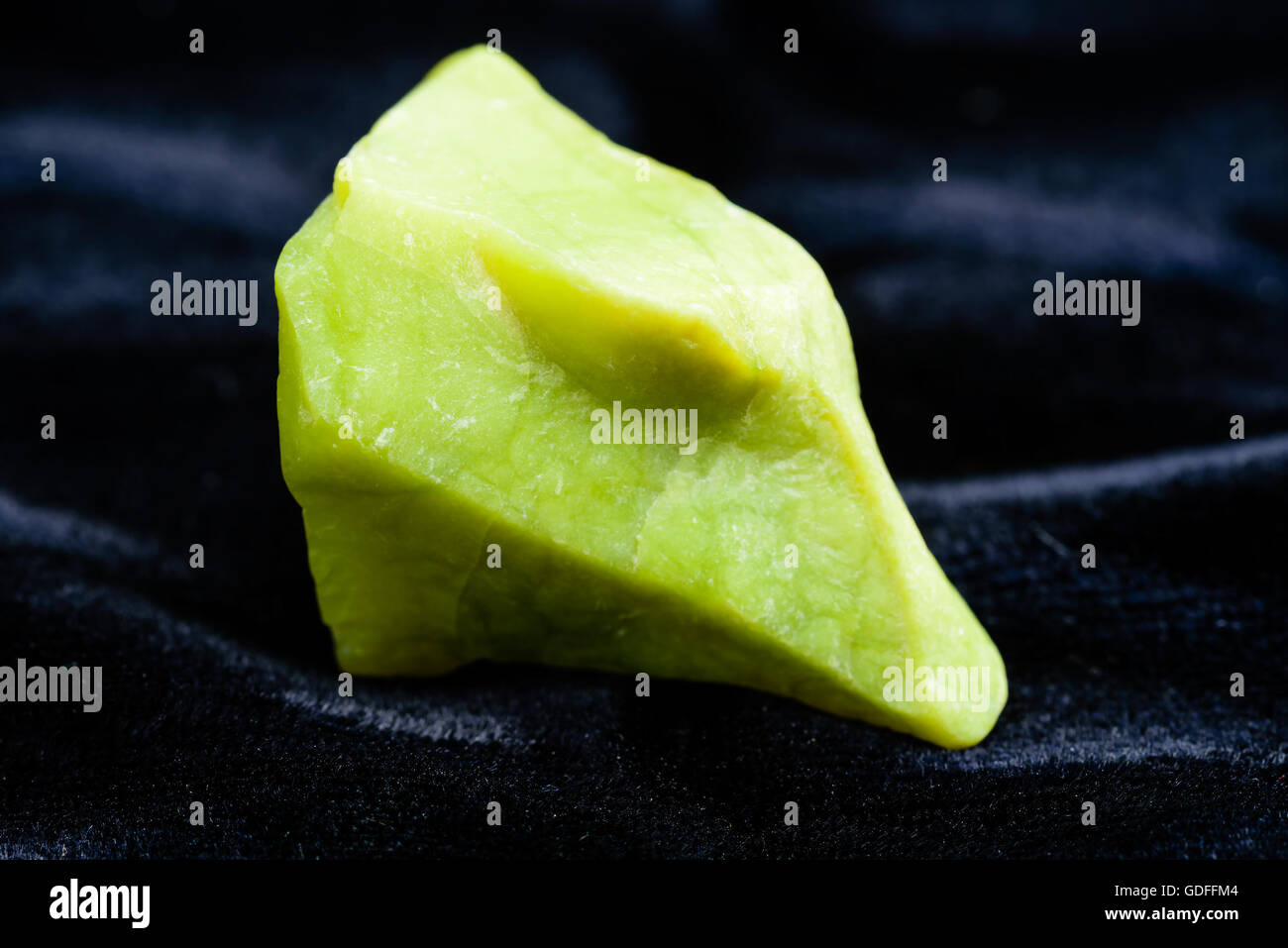 Wonderful green and rough, uncut opal on black textile. Stock Photo