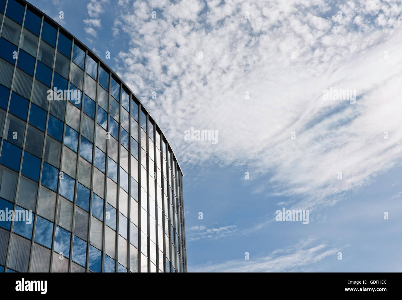 Modern office building against cloudy sky background Stock Photo - Alamy