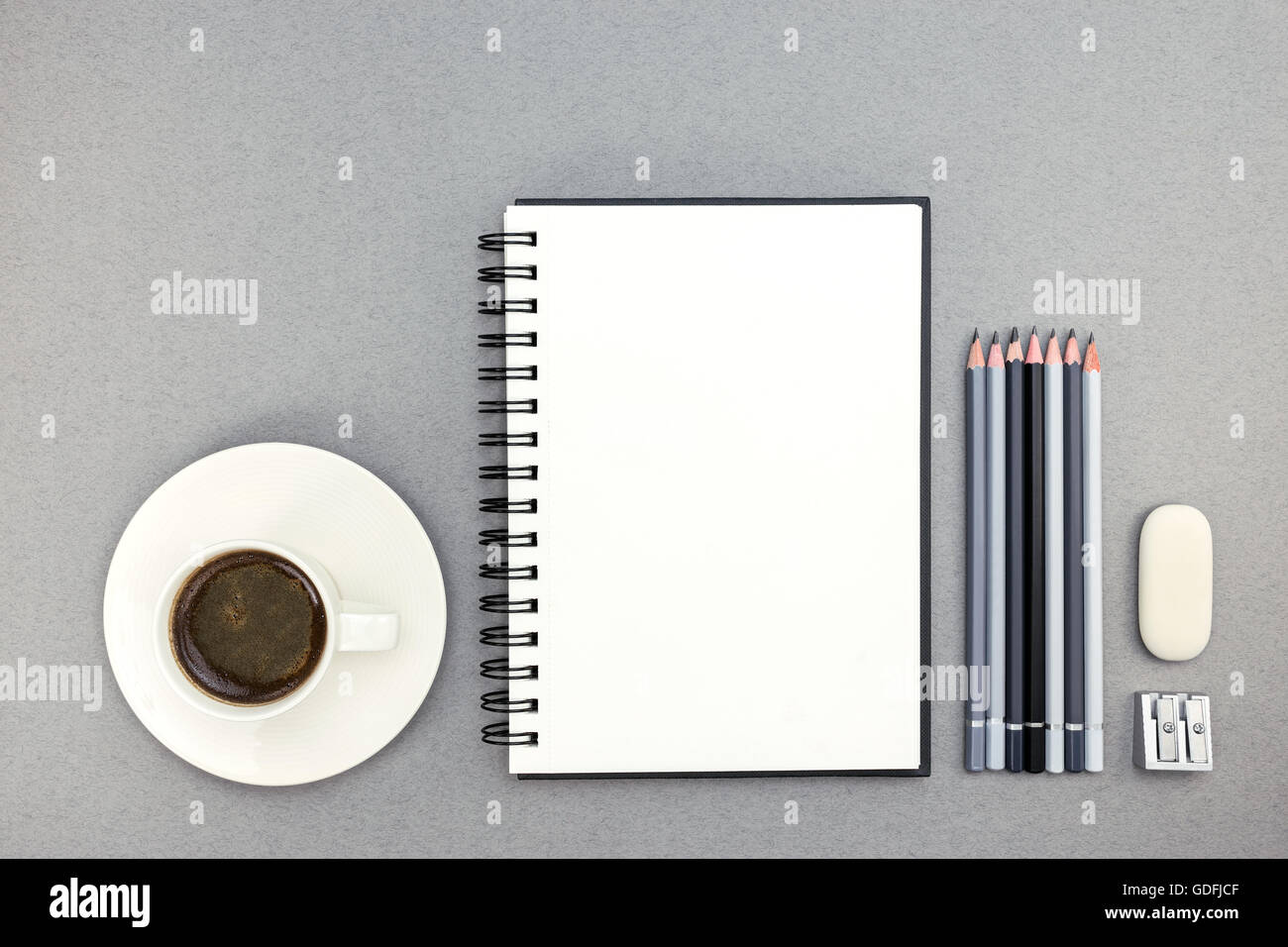 cup of coffee and notebook with drawing tools on desk, top view Stock Photo