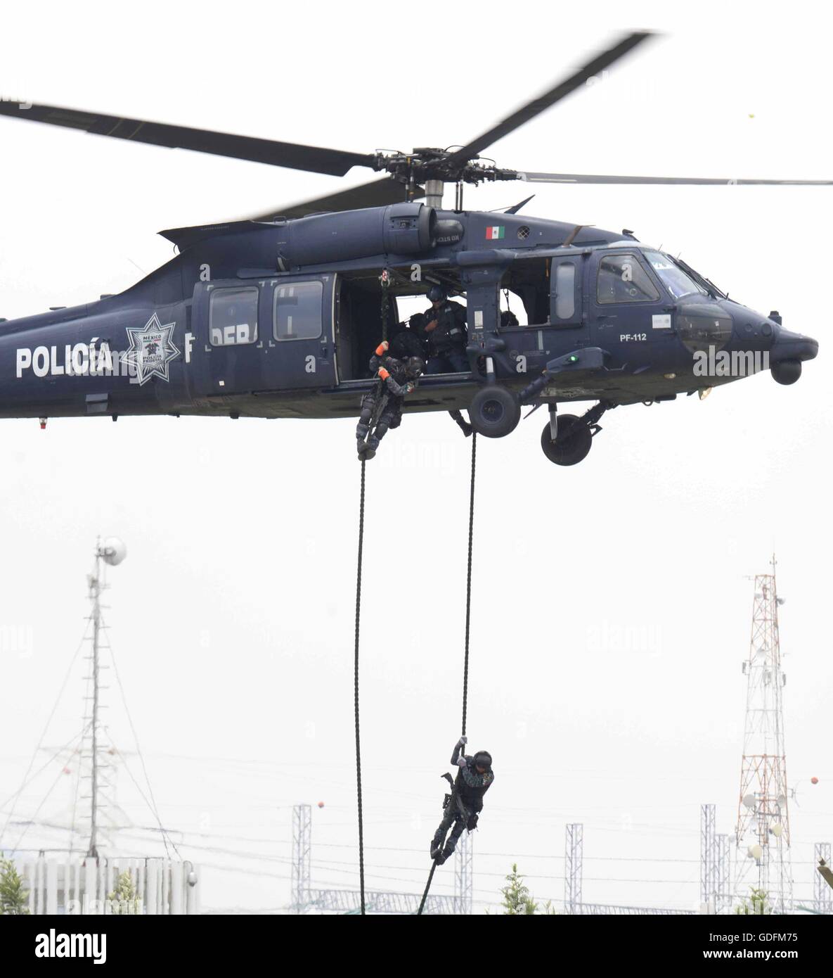 Mexican Federal Police special operation officers fast rope from a Black Hawk helicopter during the 88th anniversary of the national police force celebration attended by President Enrique Pena Nieto July 13, 2016 in Iztapalapa, Mexico City, Mexico. Stock Photo