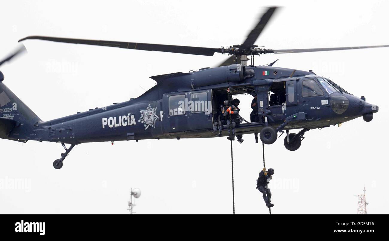 Mexican Federal Police special operation officers fast rope from a Black Hawk helicopter during the 88th anniversary of the national police force celebration attended by President Enrique Pena Nieto July 13, 2016 in Iztapalapa, Mexico City, Mexico. Stock Photo