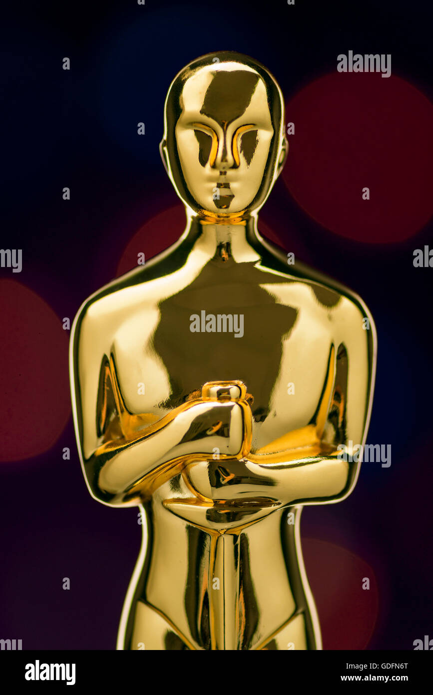 Closeup of Shiney Golden Statuette on Defocused Lights Background Stock Photo