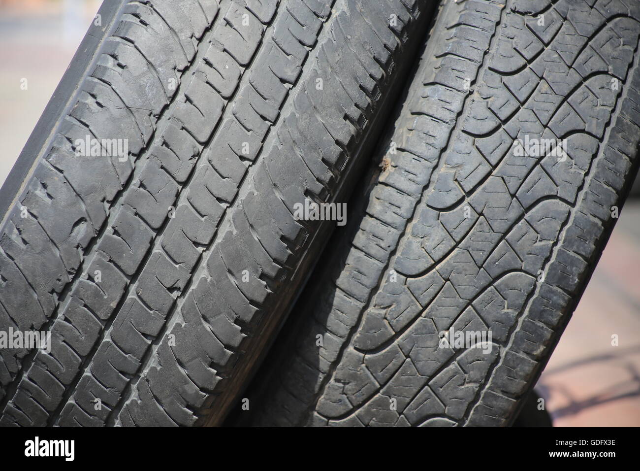 Used Tires. Stack of old used tires. Two damaged tires of private cars one on top of the other in the garage entrance. Stock Photo