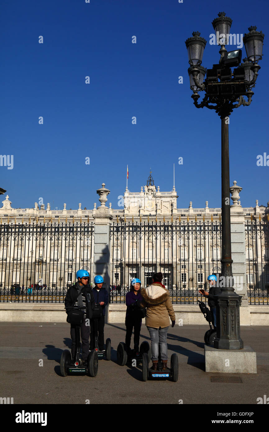 Asian tourists visiting the Royal Palace as part of a Segway tour, Plaza de la Armeria, Madrid, Spain Stock Photo