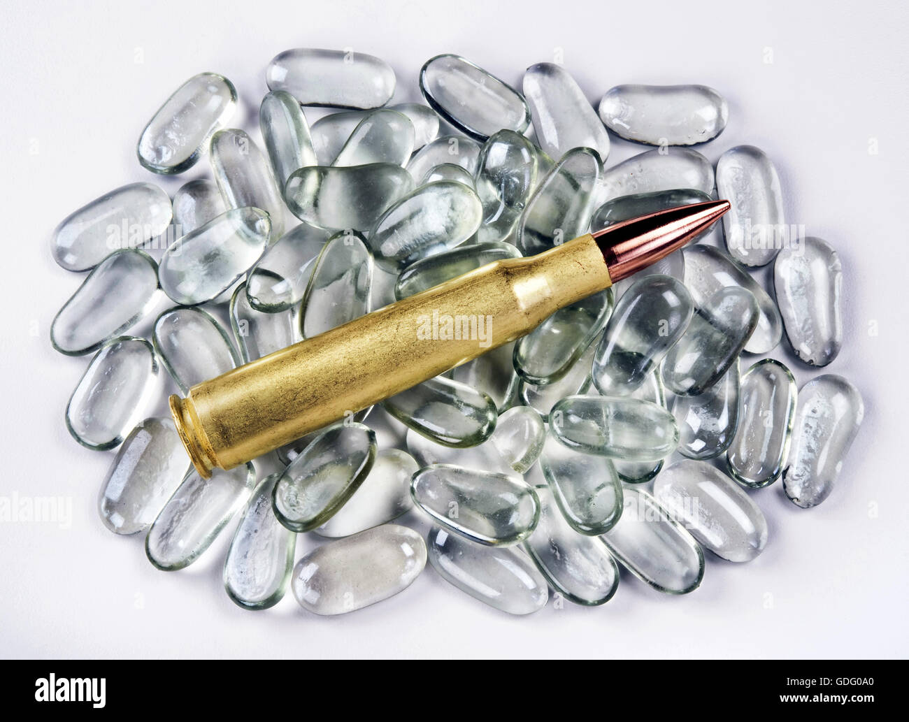 50 caliber brass bullet on polished glass stones. Stock Photo