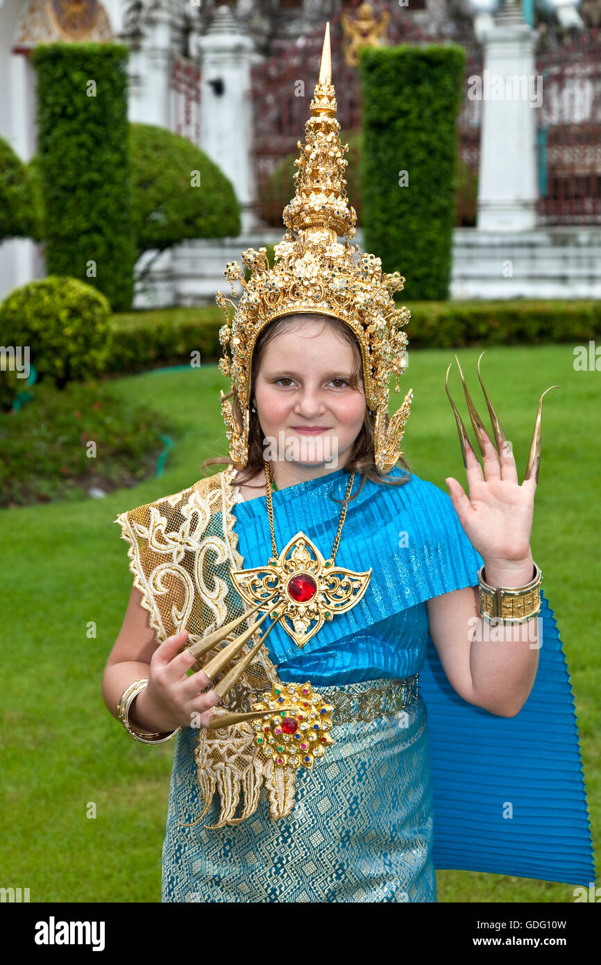Young girl tourist dressed in traditional Thai dancer costume at Wat Arun in Bangkok Stock Photo