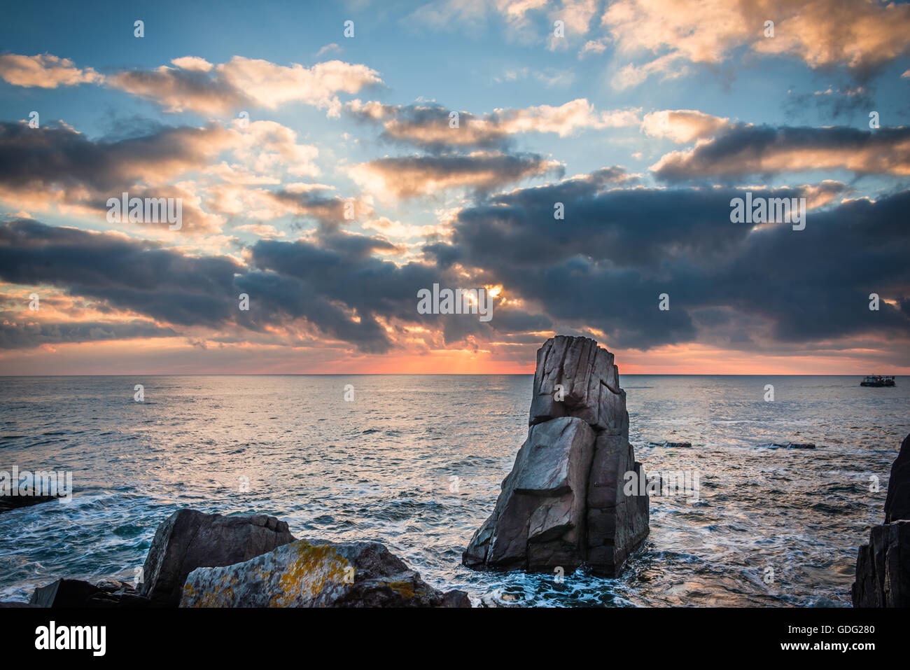 Sunrise over a rocky beach. Colorful clouds reflecting in the sea Stock ...