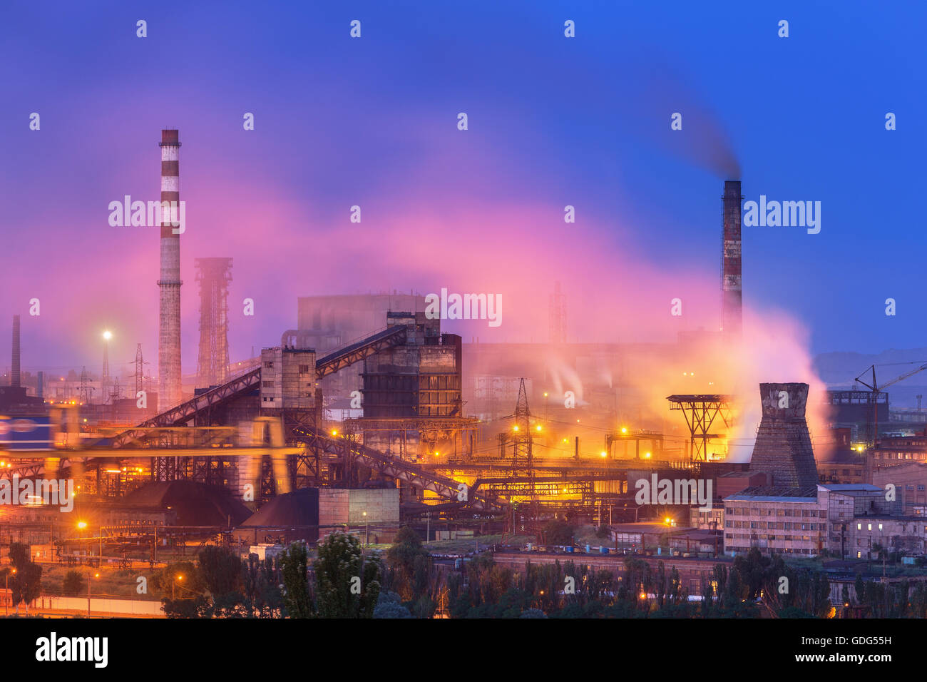 Metallurgical plant at night. Steel factory with smokestacks . Steelworks, iron works. Heavy industry in Europe. Air pollution Stock Photo