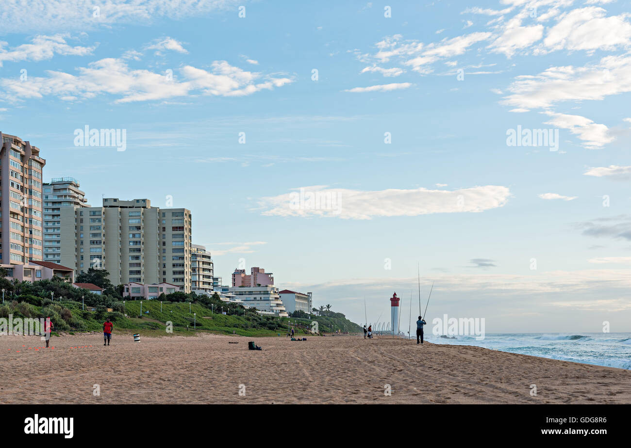 DURBAN, SOUTH AFRICA - MARCH 12, 2016: Anglers and Lifeguards on the Umhlanga Rocks beachfront with Millennium Pier and Lighthou Stock Photo
