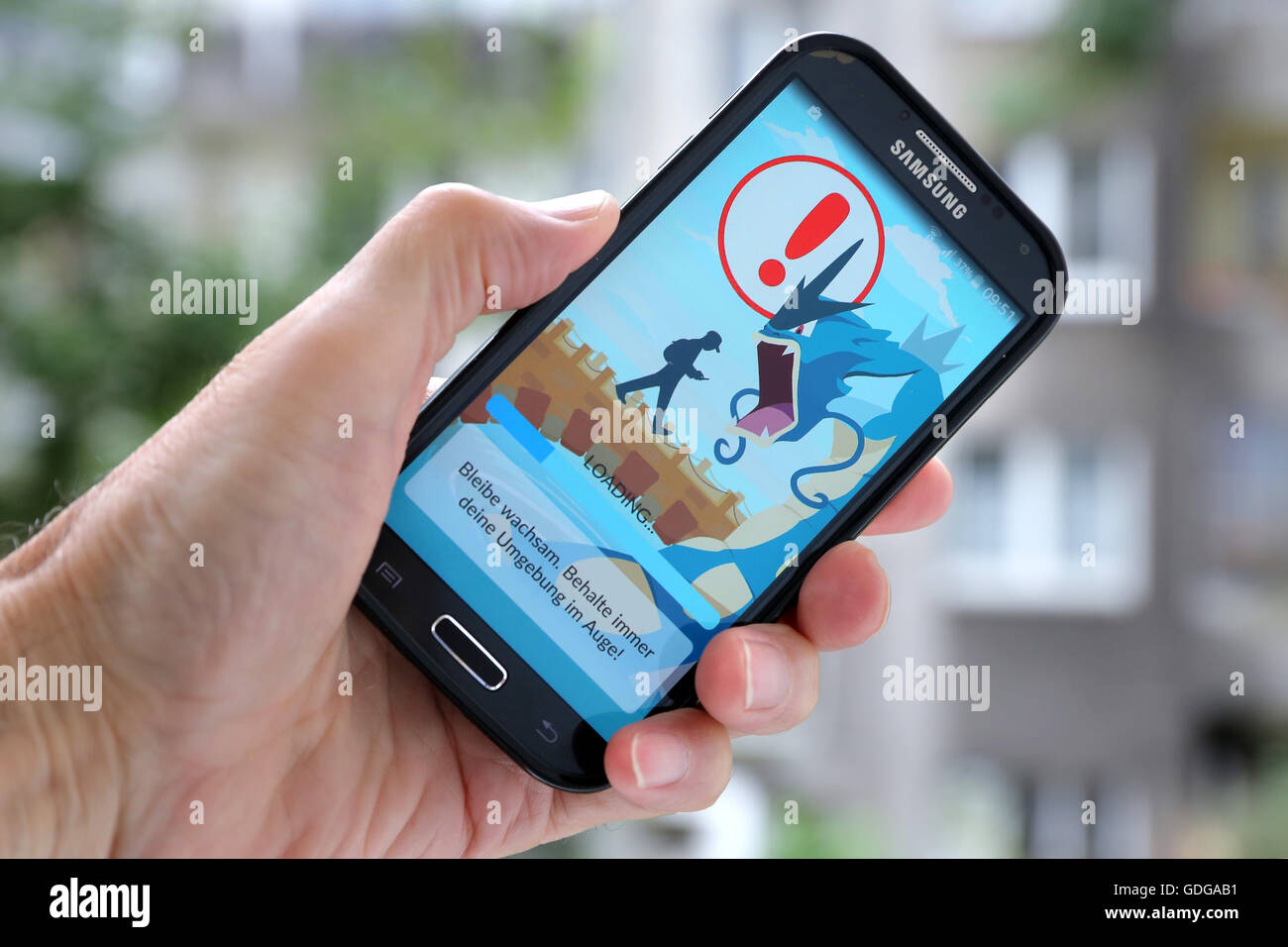 German version of the latest Nintendo game "Pokémon go" on a Samsung smartphone. The caution advises players to be aware of the surroundings while playing Pokemon Go. Dortmund, Germany, July 17th.2016 Stock Photo