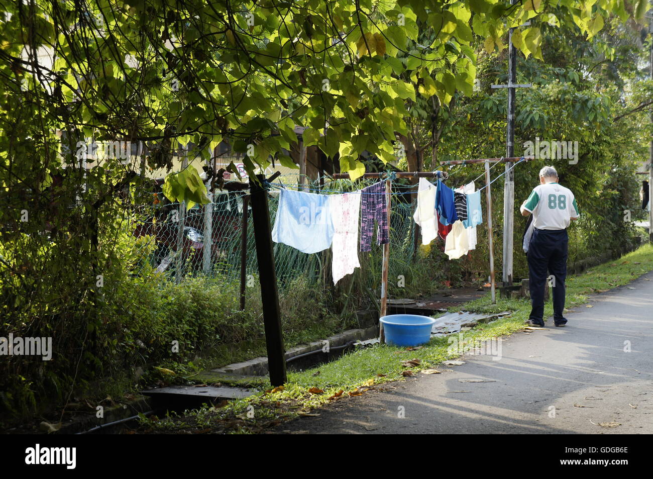a Malaysian senior citizen hanging laundry Stock Photo
