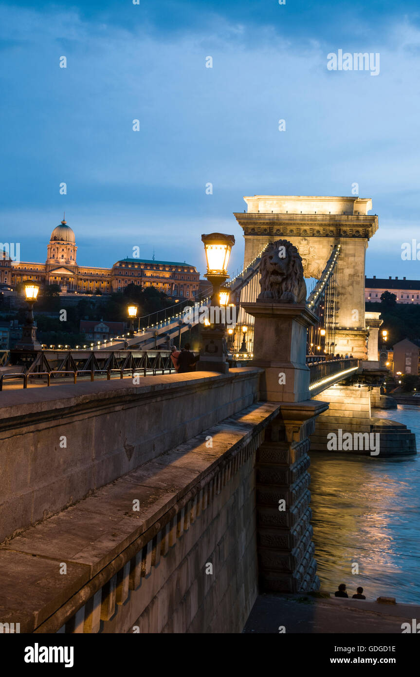 At dusk and the lights switched on both the former Royal Palace and the oldest bridge, Széchenyi Chain Bridge in Budapest in Hun Stock Photo