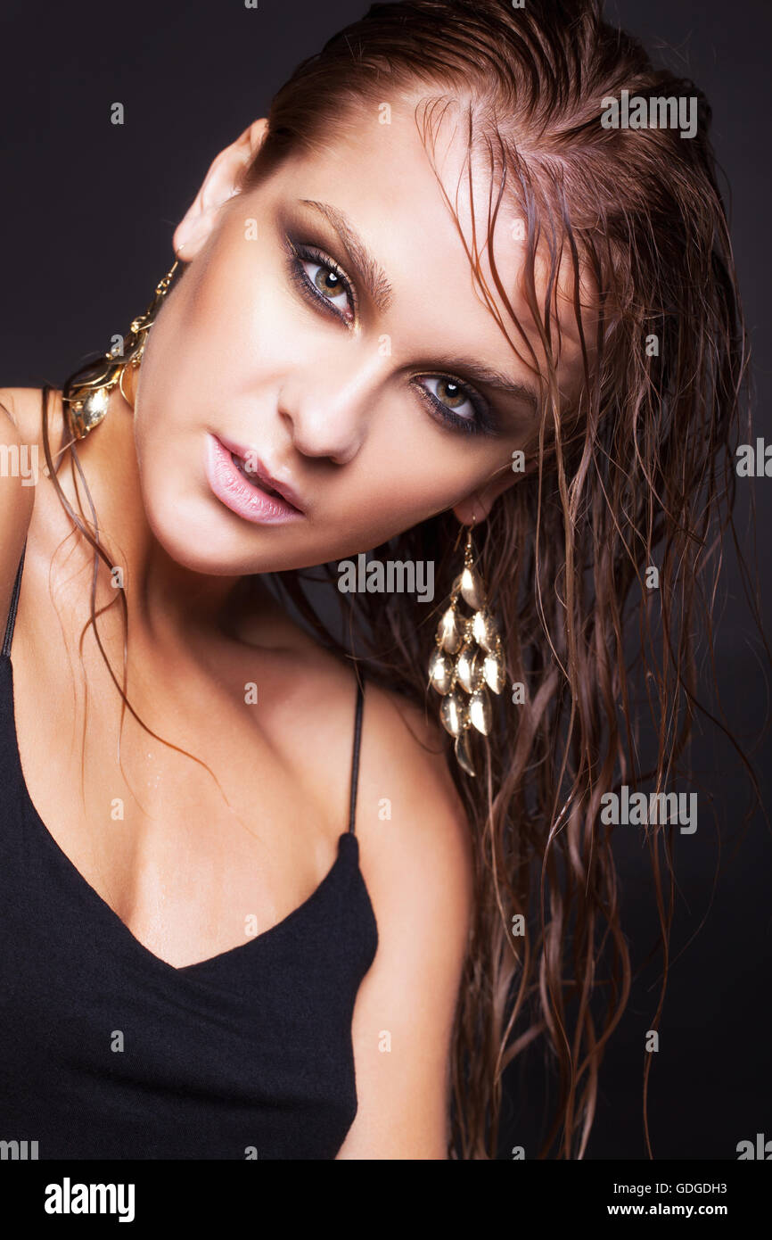 Portrait of young beautiful woman with wet shining  makeup  on black background Stock Photo