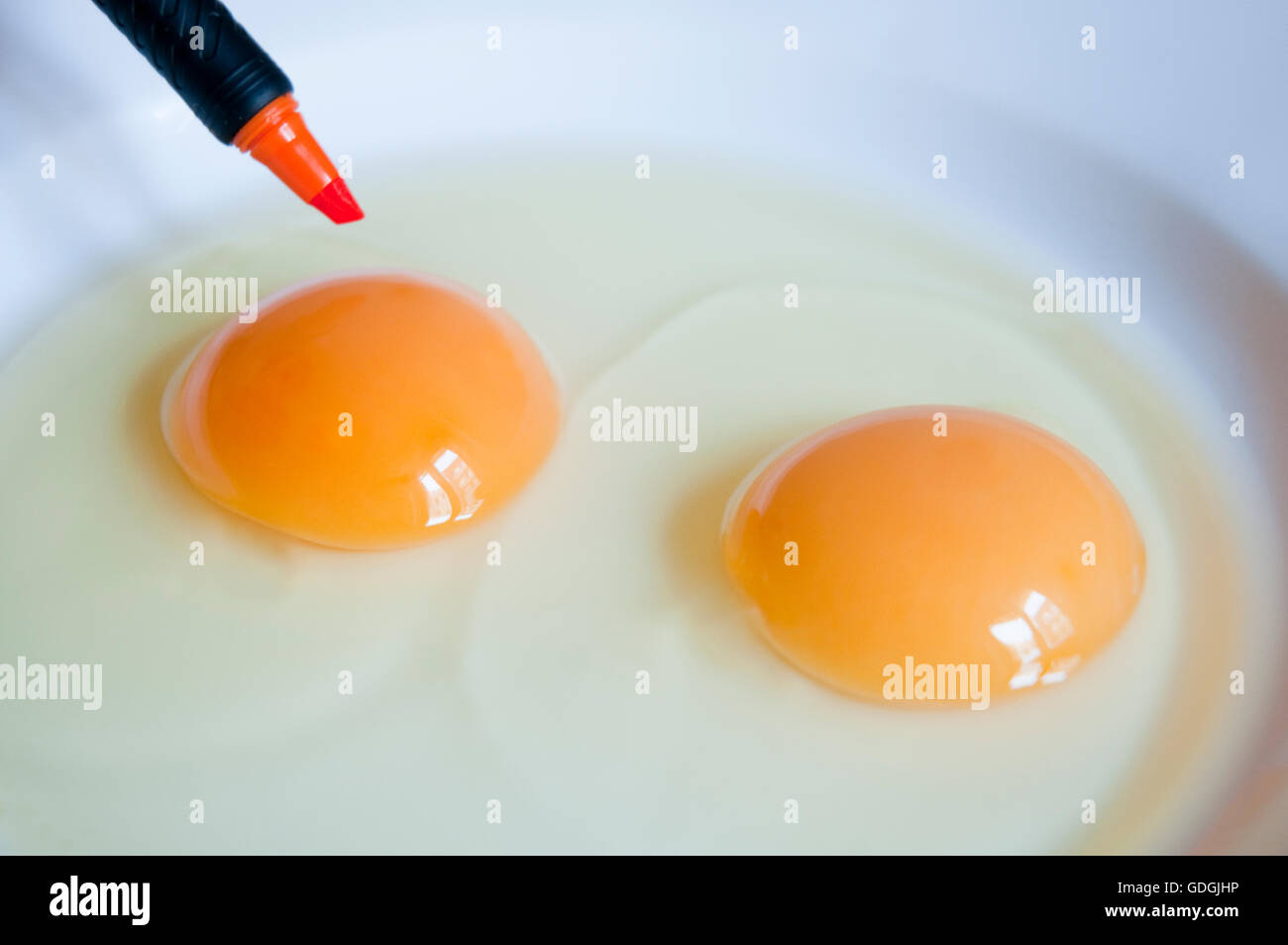 Two eggs and orange felt-tip pen. Close view. Stock Photo
