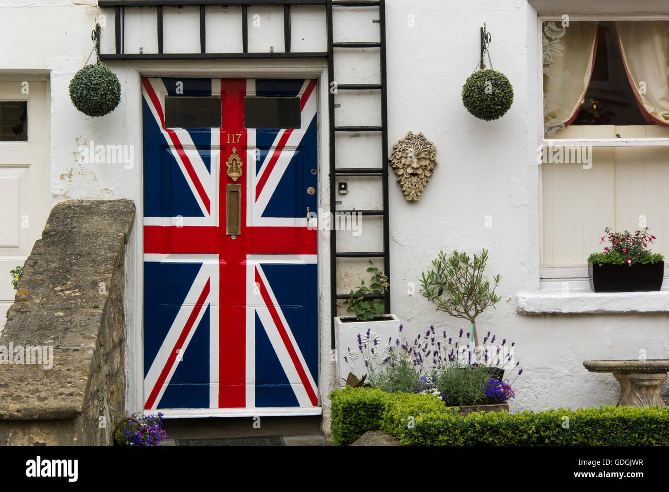 Door painted with Union Jack flag. Front door of house painted in red white and blue of British flag Stock Photo
