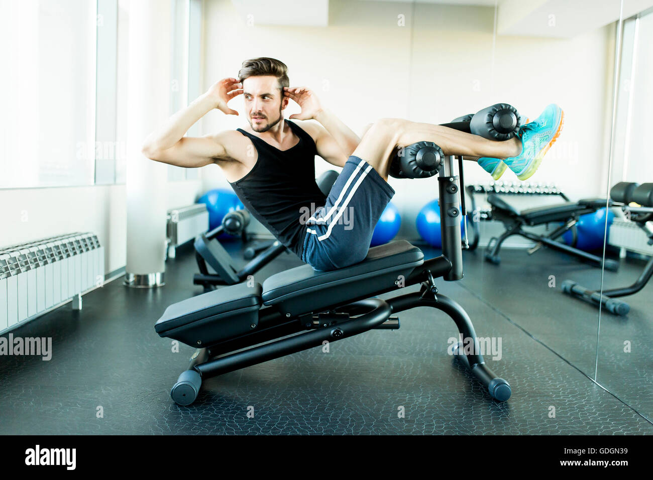 Young man doing exercises for abdominal muscles at the gym Stock Photo