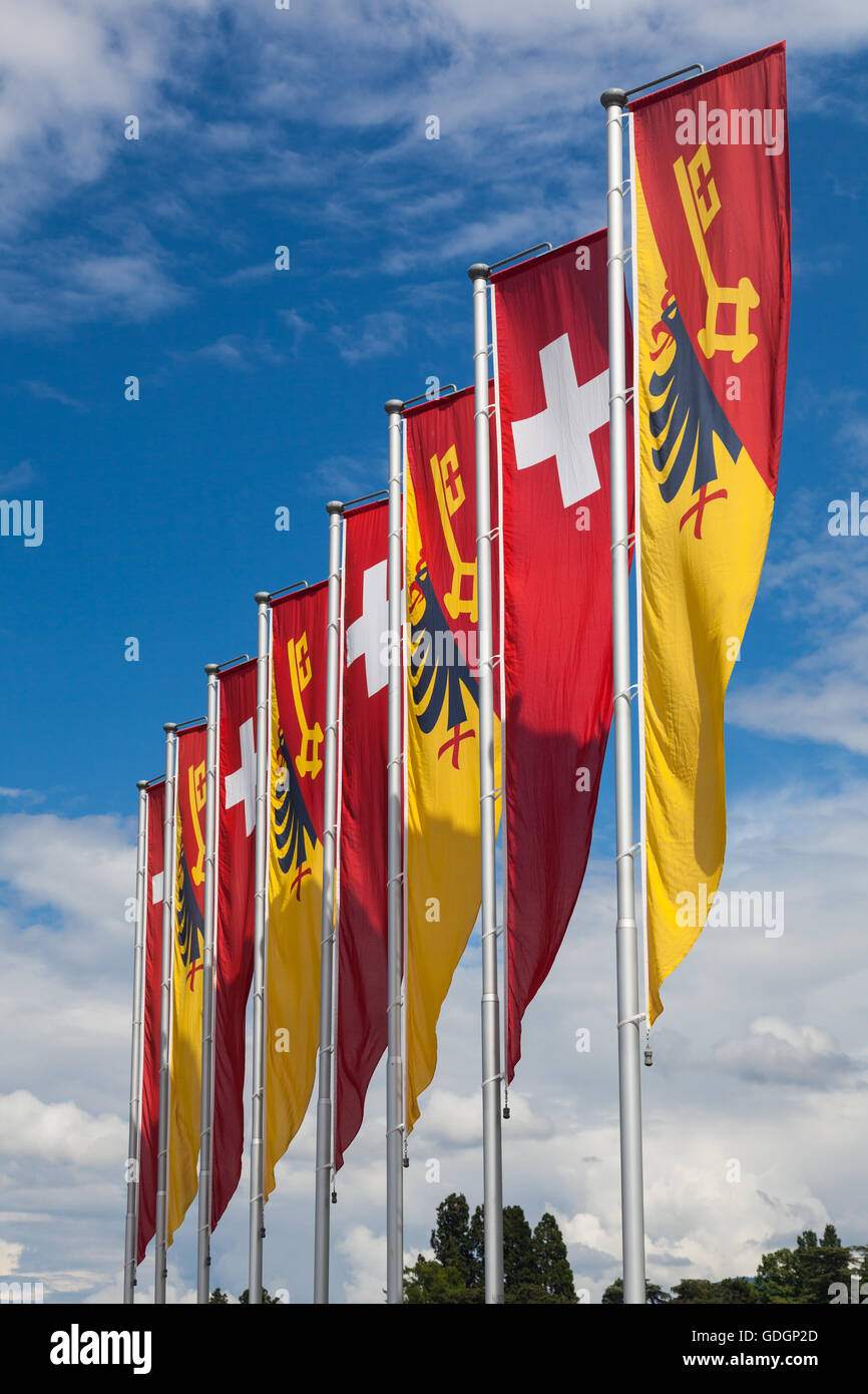 Swiss flag and Canton of Geneva banners blowing in the wind by Lake Geneva Stock Photo