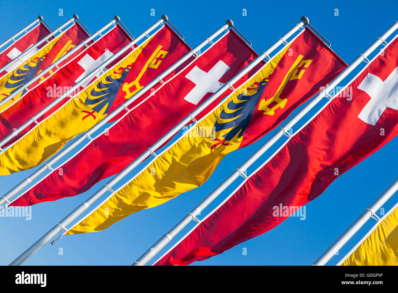 Swiss flag and Canton of Geneva banners blowing in the wind by Lake Geneva Stock Photo
