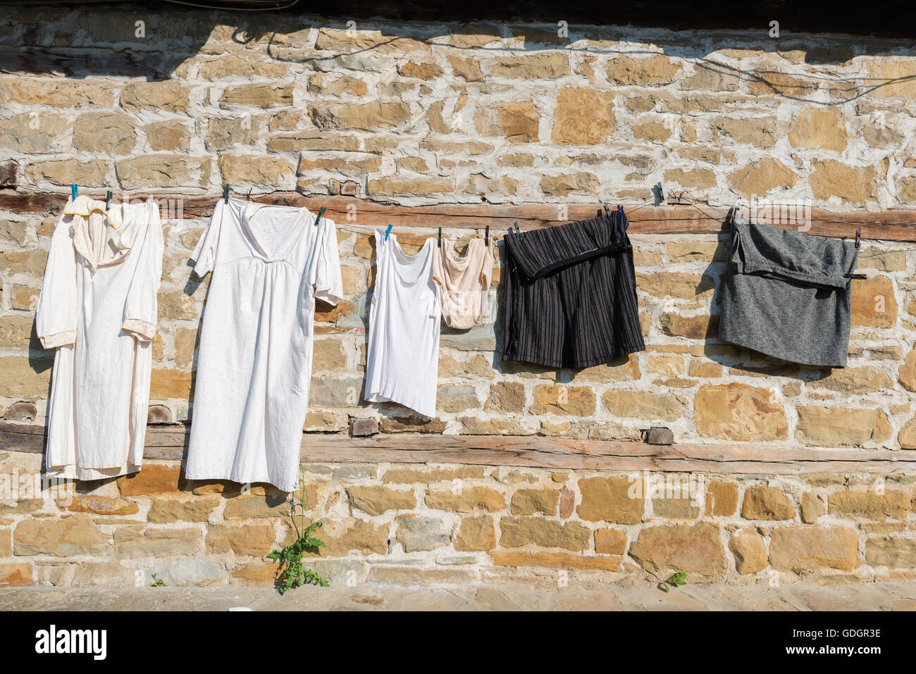 Underwear and clothing hanging drying on ancient stown wall in Tryavna, Bulgaria Stock Photo
