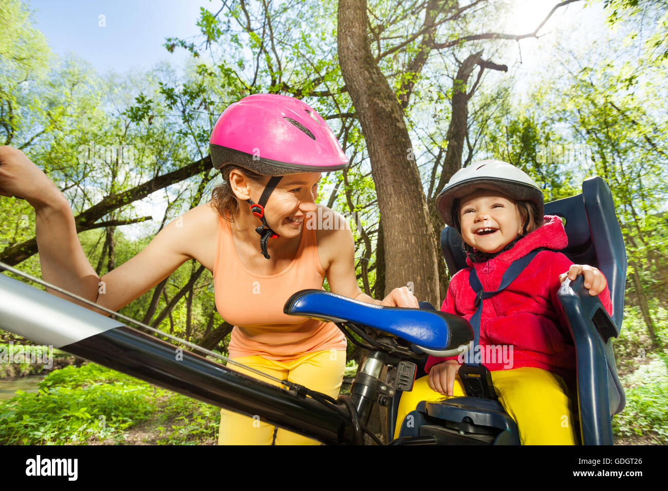 Happy little girl in bike seat with her mother Stock Photo