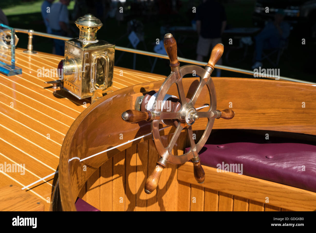 Helm and brass navigation lights on an antique wooden boat. Stock Photo