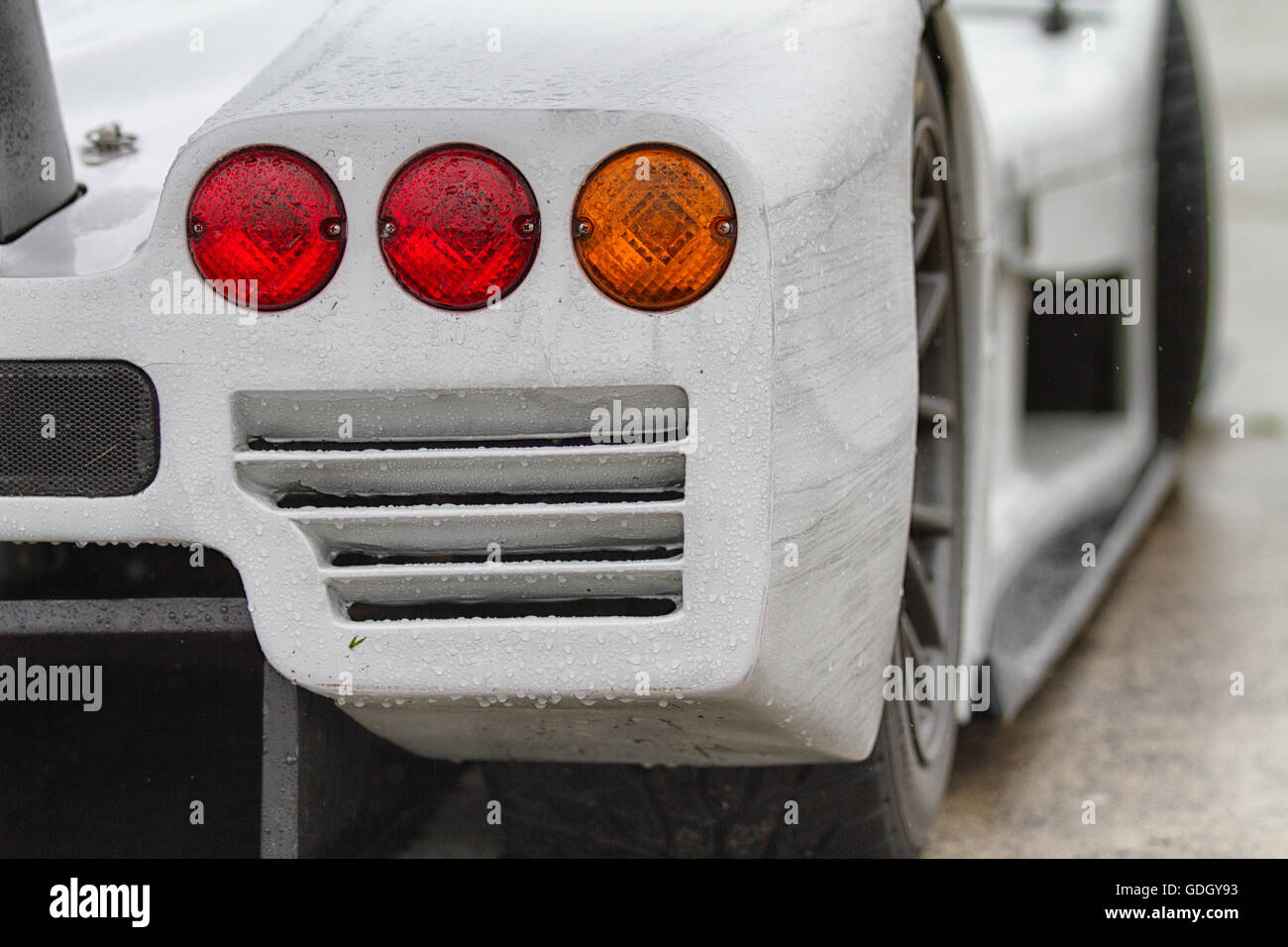 Close up on a section of racing car you can see 3 round rear lights. Stock Photo