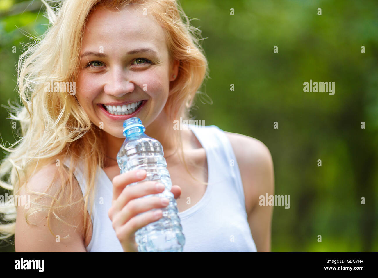 Closeup portrait of smiling woman with water bottle Stock Photo - Alamy