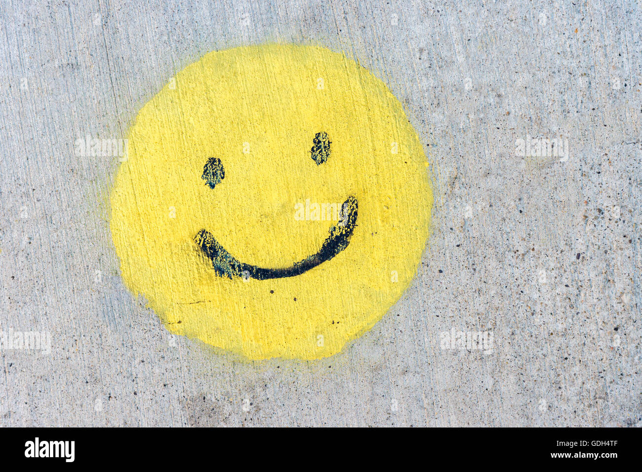 Yellow smiley painted on sidewalk Stock Photo