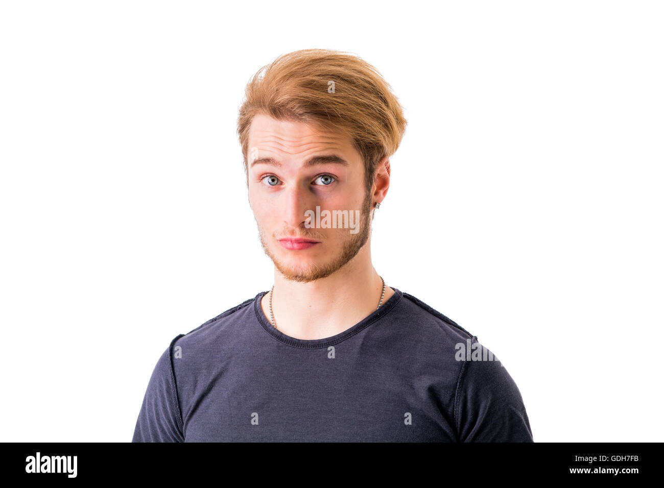 Sad or worried handsome young man looking down, isolated on white Stock Photo