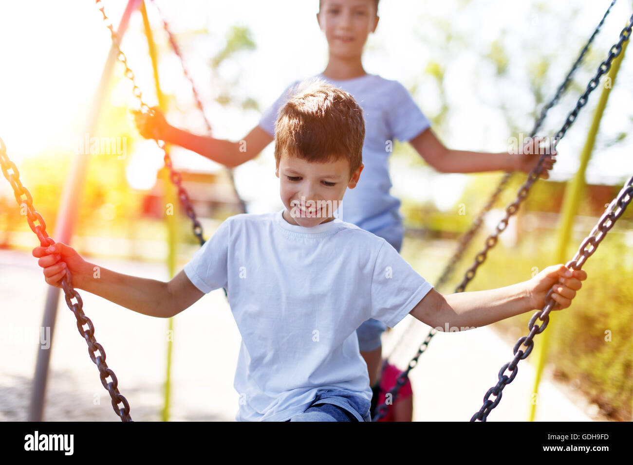 Little boys climbing on jungle gym outdoor in sunset Stock Photo