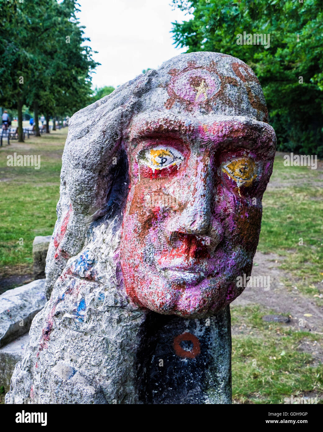 Gorlitzer Park, Kreuzberg. Stone sculpture, man holding head with large hand and dollar signs in eyes Stock Photo