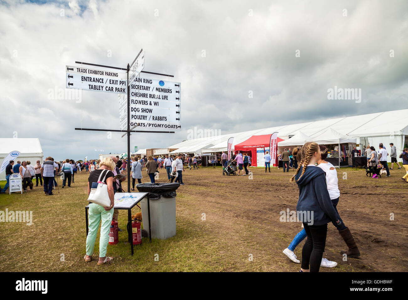 Woman looking at map below a  sign post with directions to exhibits at he Royal Cheshire Show. UK 2016 Stock Photo