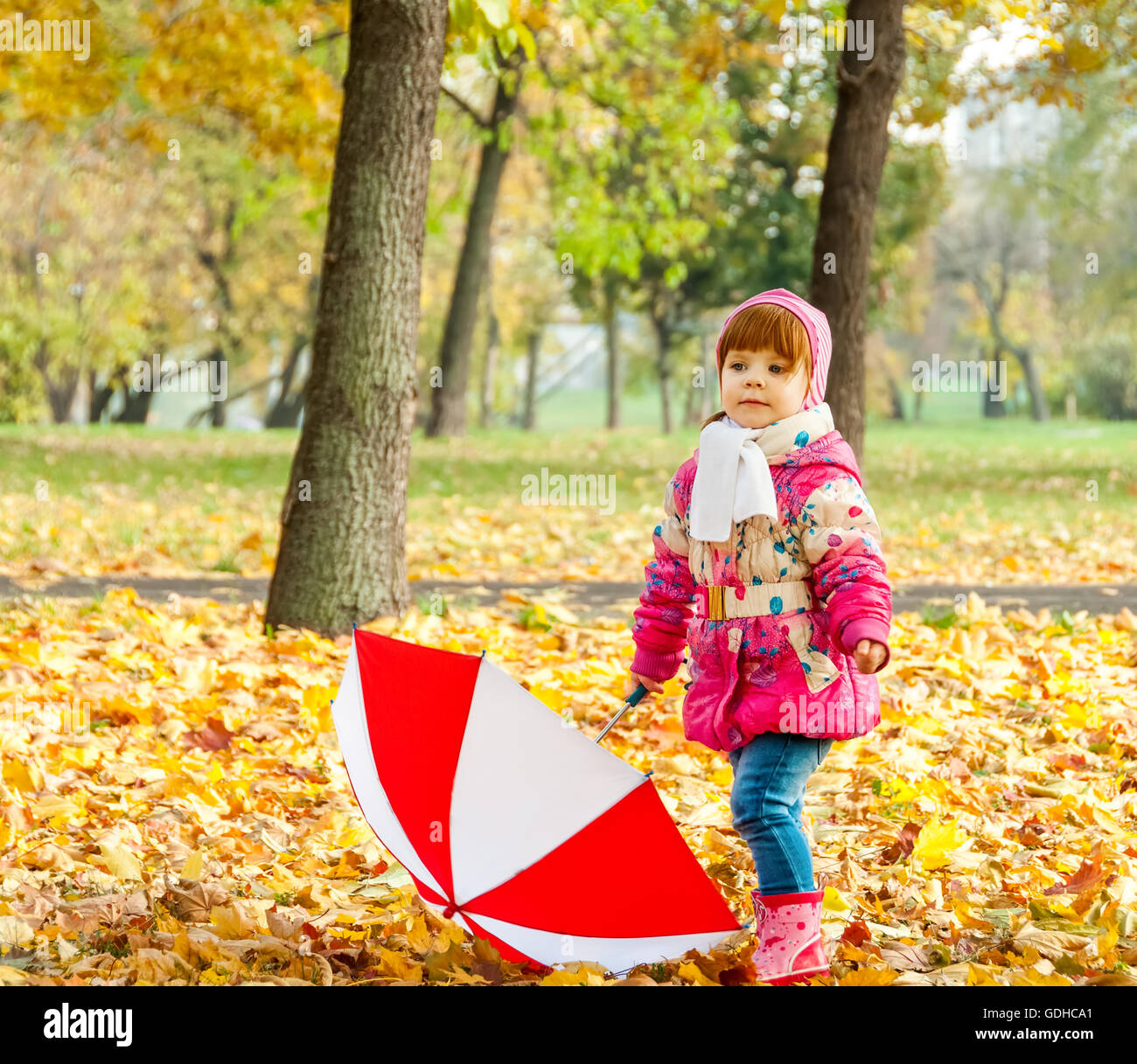 A little girl walking in the park with an umbrella Stock Photo - Alamy
