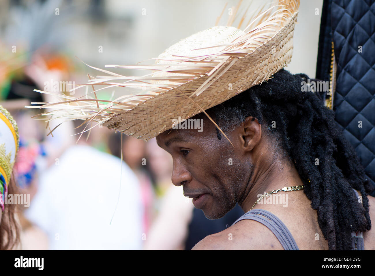 Man in straw hat with dreadlocks. Bath Carnival procession, bringing a South American festival atmosphere to Somerset Stock Photo