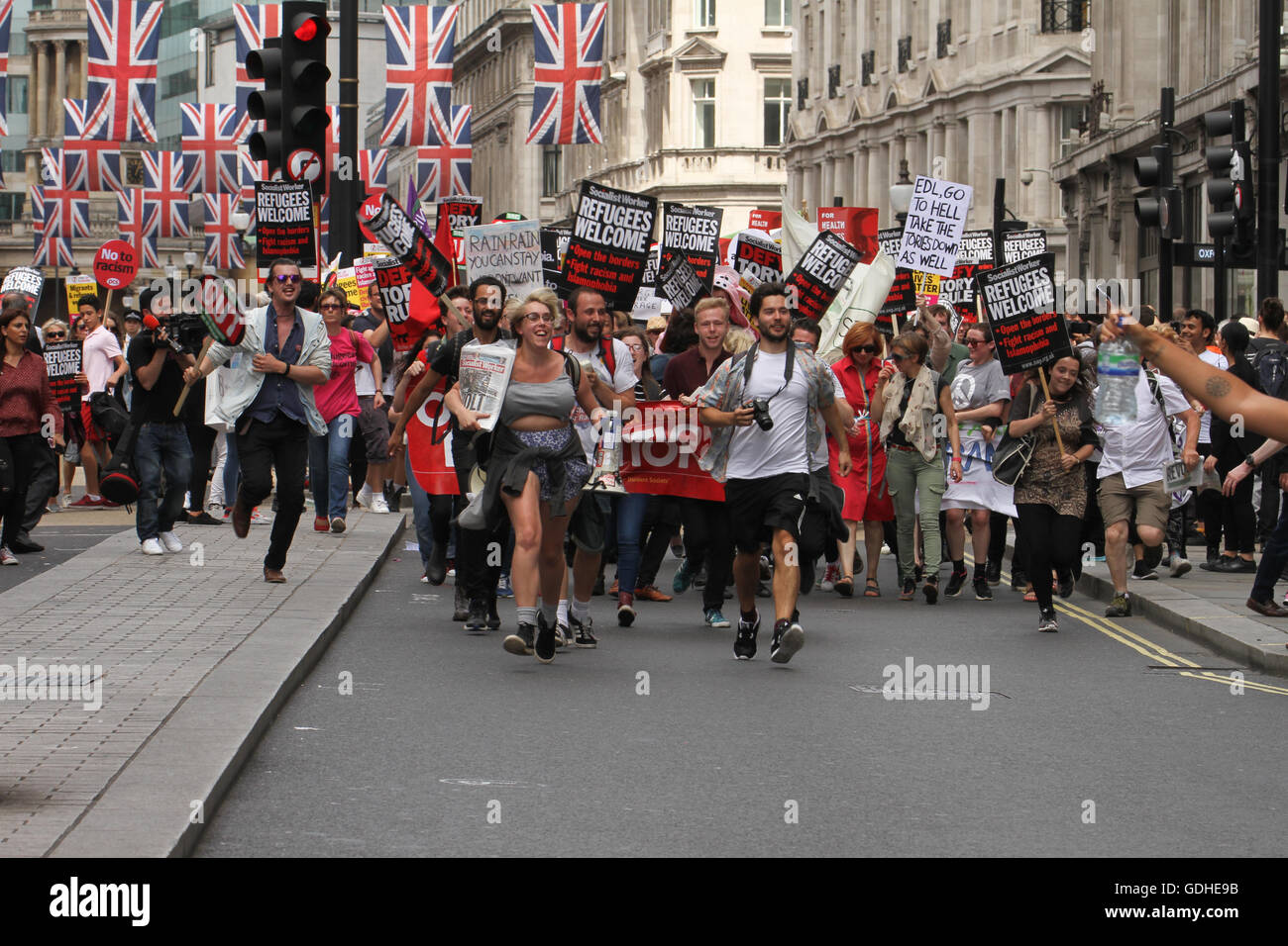 London, UK. 16th July, 2016 Protesters run to catch up on the march at Regent Street. Hundreds of people take part in a demonstration outside the BBC offices at Portland Place and march to Parliament Square WC1, united in demanding for an end to Austerity, No To Racism and demanding and end to the Tory rule. The demonstration on 16 July called by the People's Assembly and Stand Up to Racism is the positive and united response After the Brexit referendum. Credit:  david mbiyu/Alamy Live News Stock Photo
