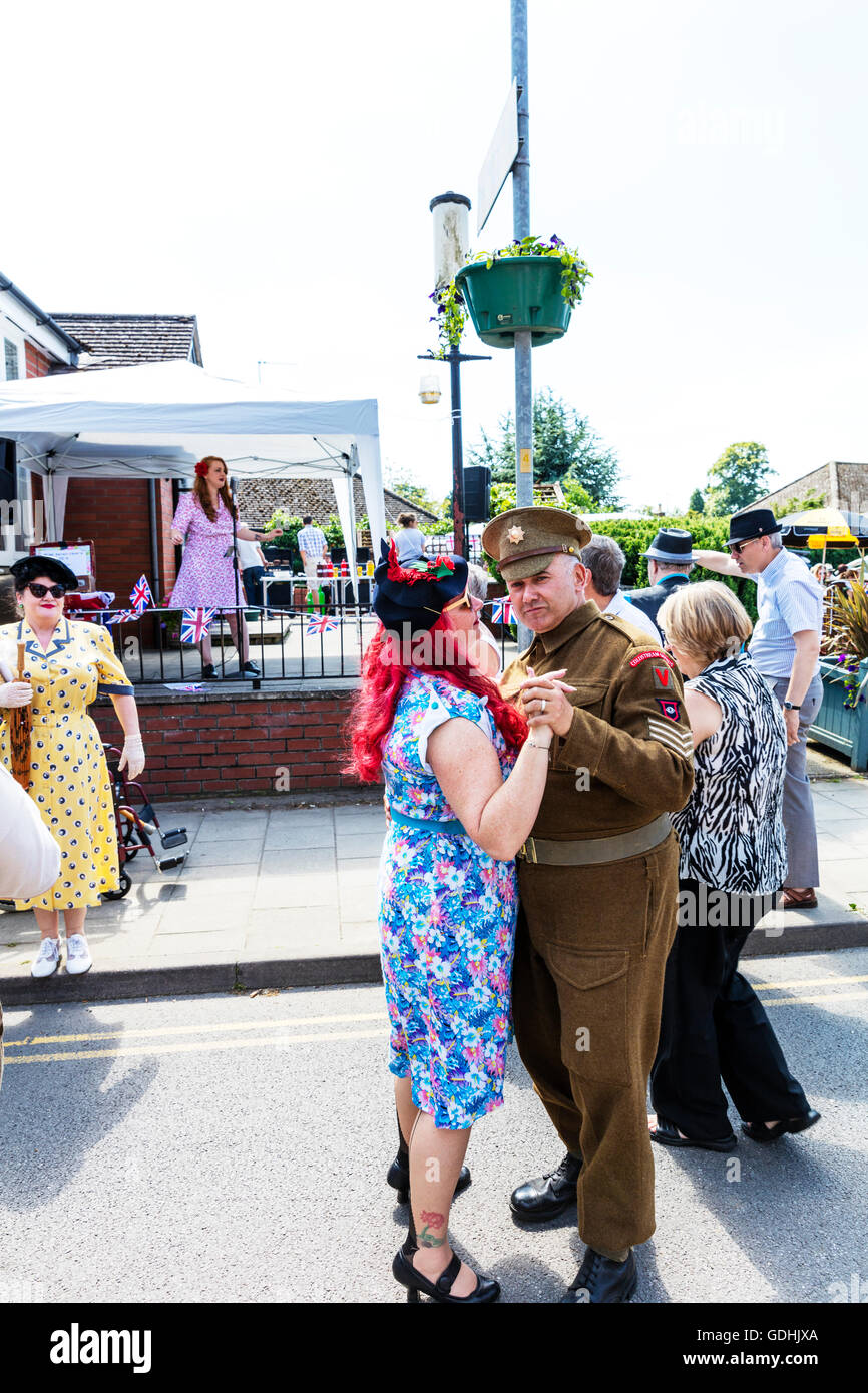 Dancing in the street outside army man and wife enjoying dance waltz waltzing 1940's Weekend at Woodhall Spa Lincolnshire UK England on 17/07/2016 The UK's largest 1940's weekend People and vehicles from the WW1 World War 1 era veterans in traditional dress uniform uniforms and attire. Huge vintage event as the sunny weather draws the crowds to revel in a day of vintage music, dance, fashion, memorabilia, entertainment and classic cars on a 1940's theme. They enjoy live vintage music, classic cars & military vehicles, dancing displays & re-enactments Credit:  Tommy  (Louth)/Alamy Live News Stock Photo