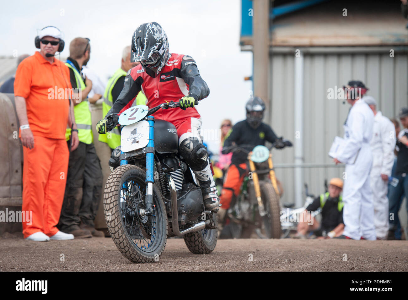 Kings Lynn, Norfolk, United Kingdom. 16.07.2016. Fifth annual Dirt Quake festival at the Adrian Flux Arena, Norfolk. Dirt Quake is racing road bikes on a dirt track. Lorry mechanic, Mortorbike Racer and TV celebrity Guy Martin races on a Crazy Horse Harley Davidson and World Superbike racer, Carl Fogerty MBE (pictured) races a Triumph. Classes include Inappropriate Road Bike, Ladies, and Street Tracker. Stock Photo