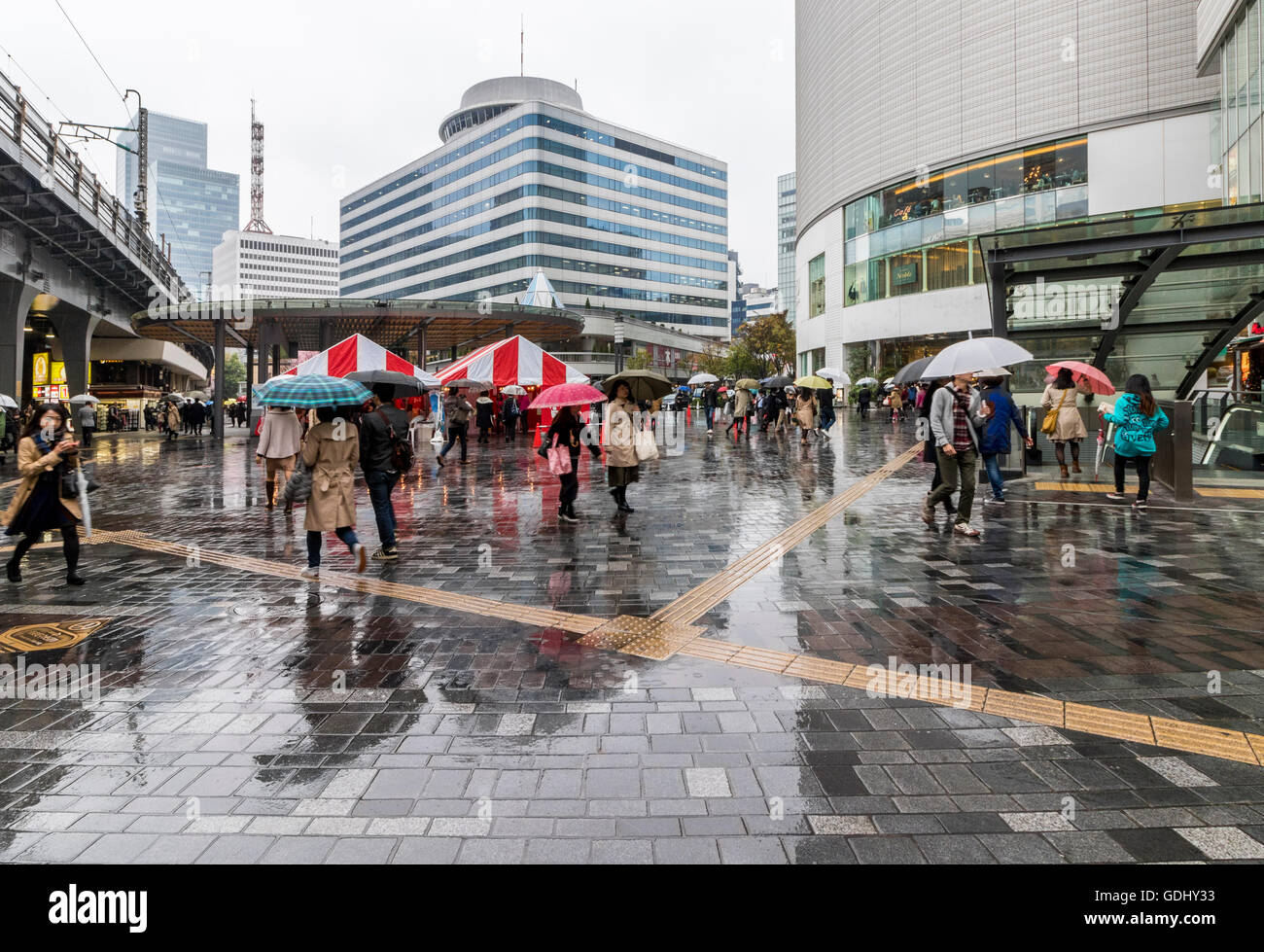 people-taking-cover-on-rainy-day-in-tokyo-japan-near-main-railway