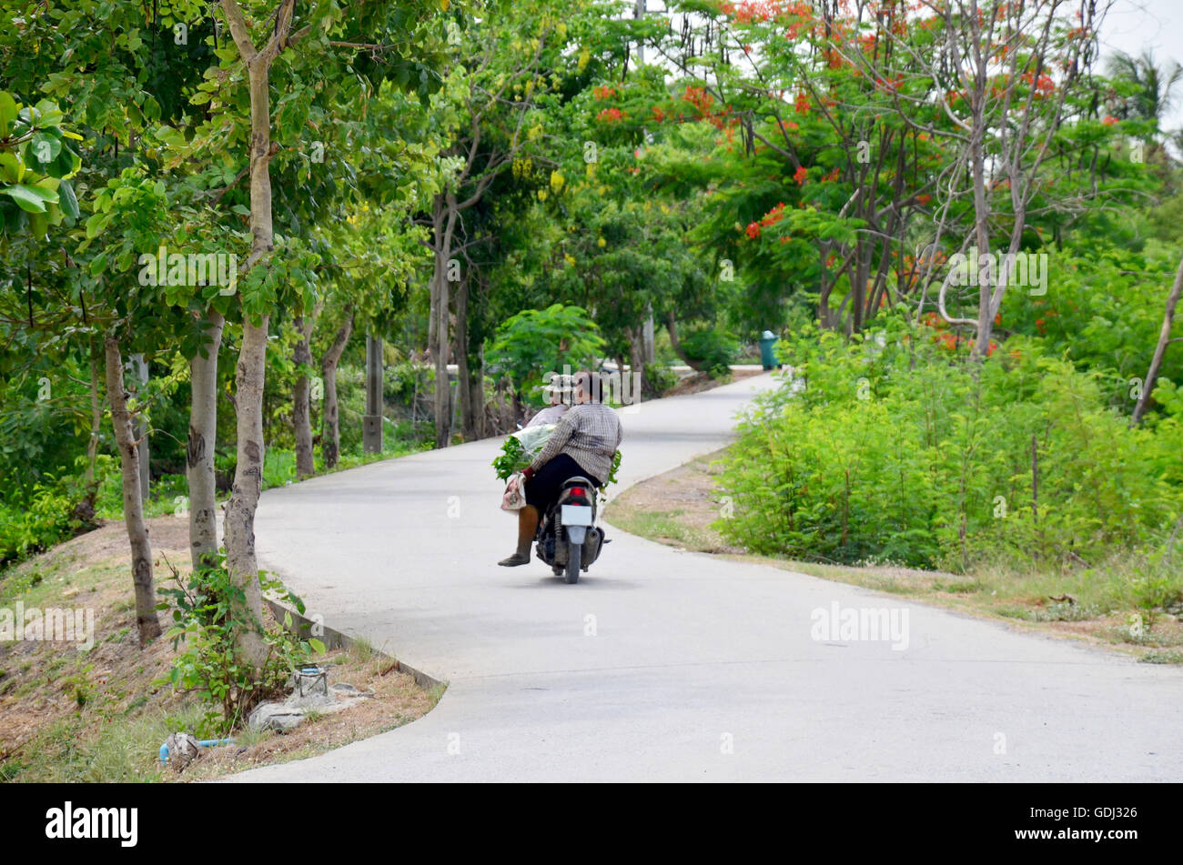 Thai people riding motorcycle on street go home after shopping a market in countryside on May 27, 2016 in Nonthaburi, Thailand Stock Photo