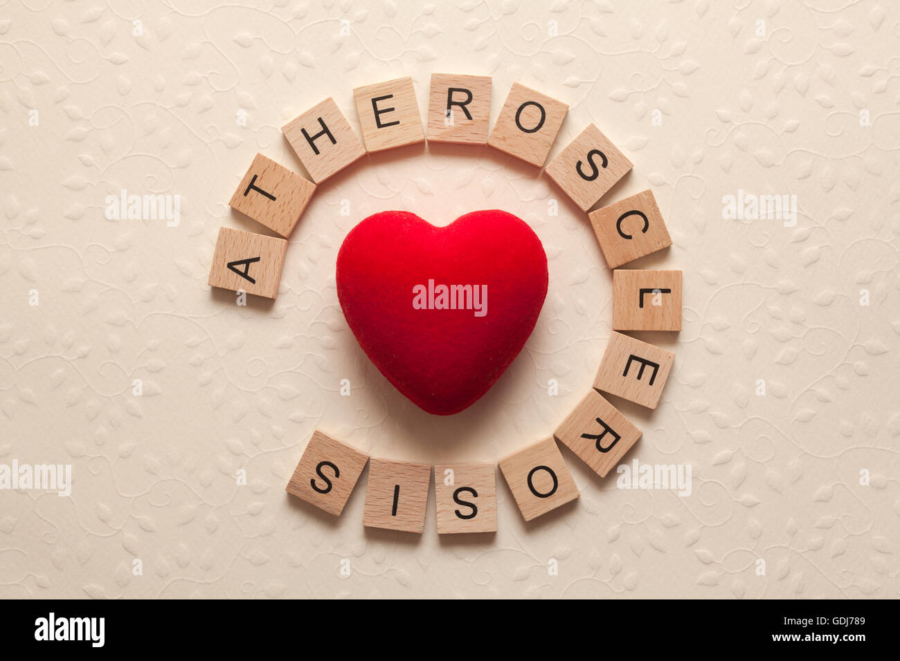 The word atherosclerosis formed with wooden letters and a heart in the middle Stock Photo