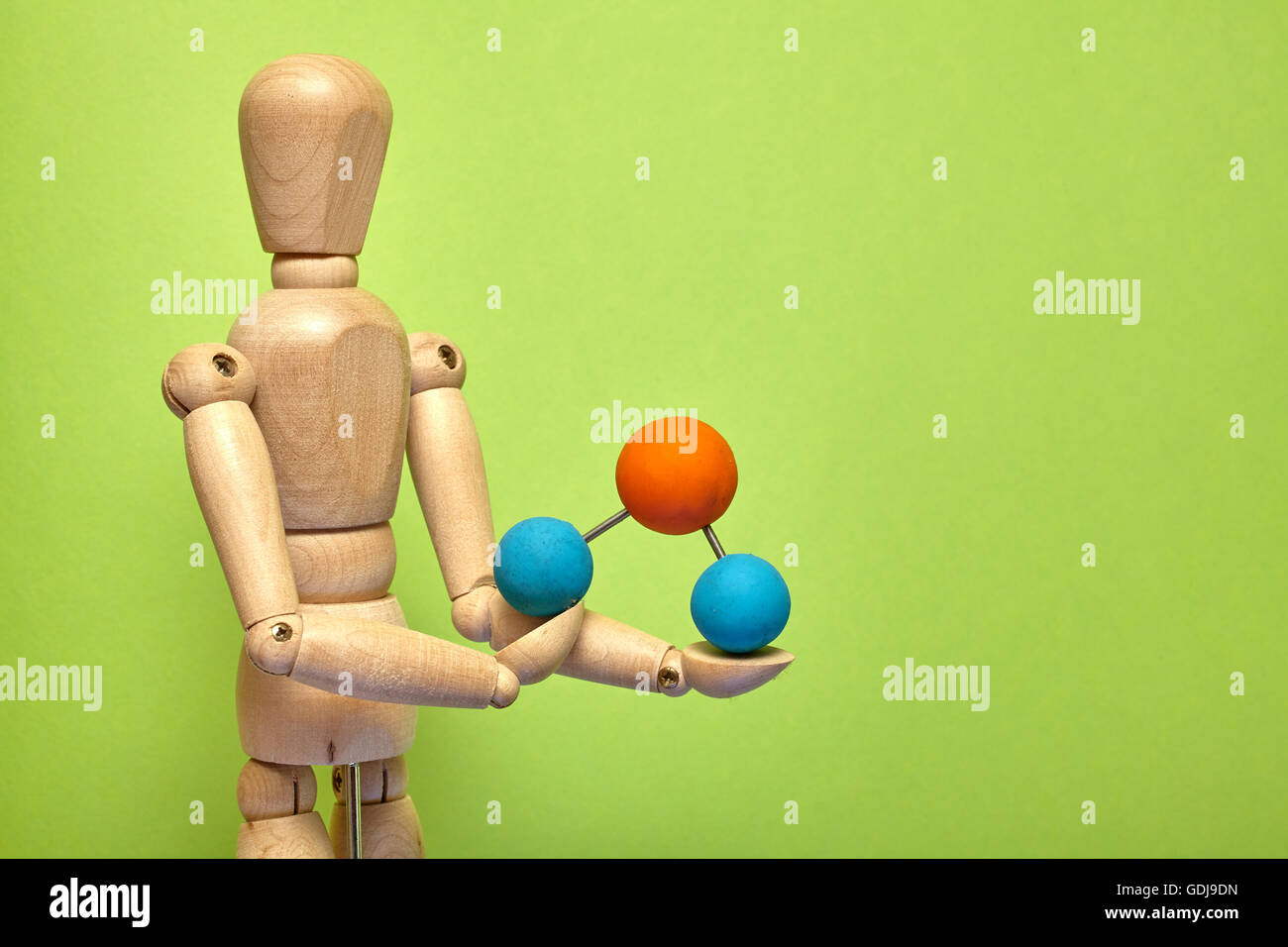 Wooden puppet with molecule on green background Stock Photo - Alamy