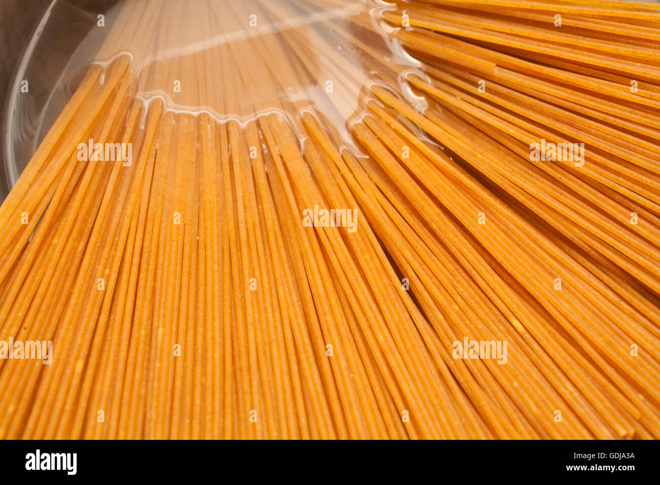 Wholemeal spaghetti into the casserole Stock Photo