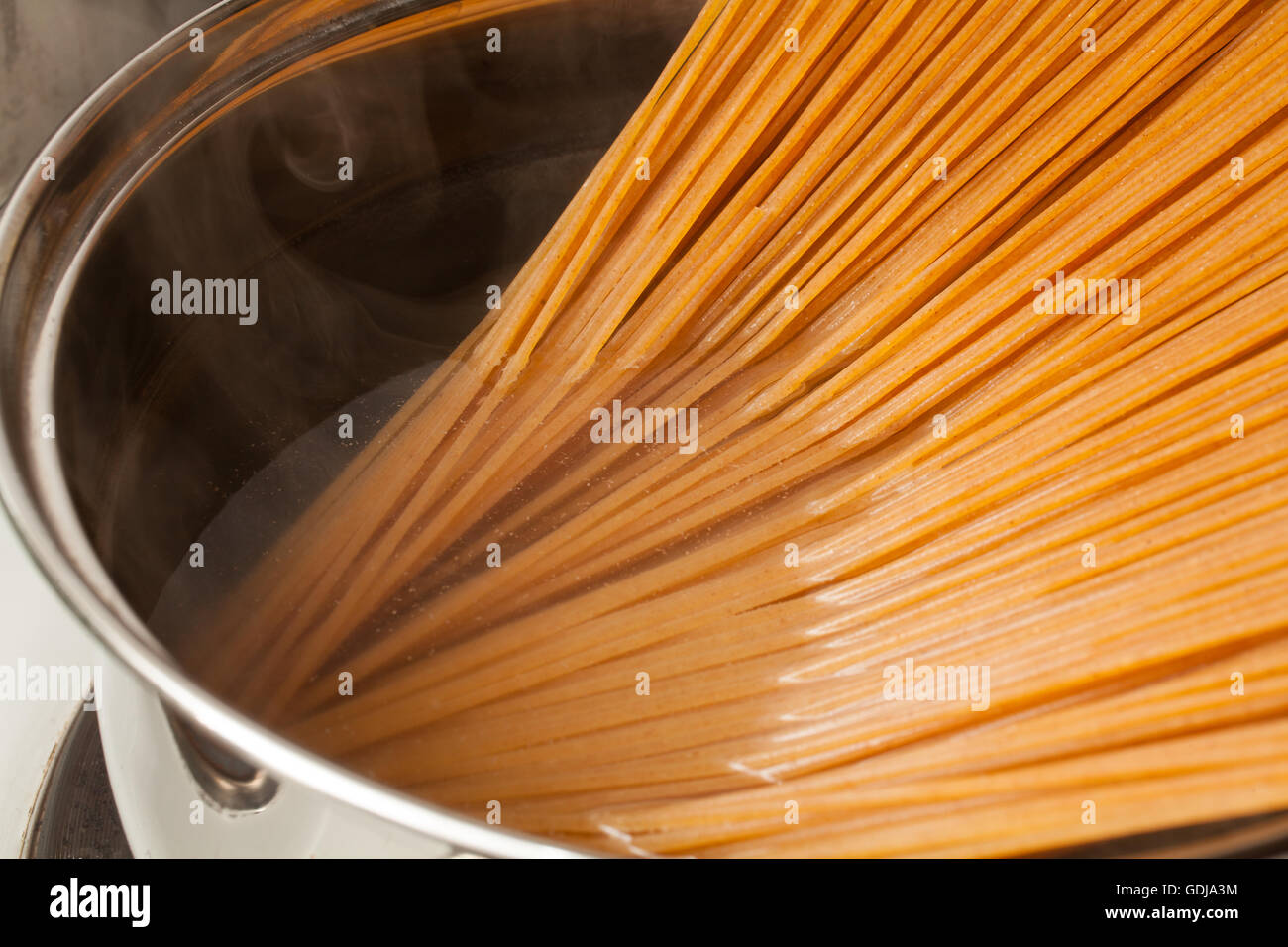 Wholemeal spaghetti into the casserole Stock Photo