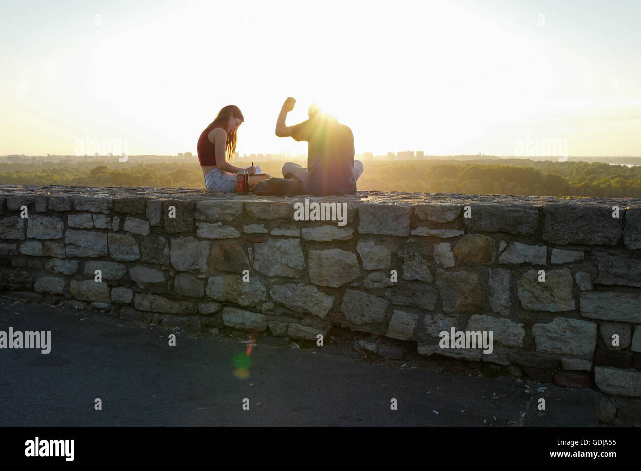 Woman sitting on a wall hi-res stock photography and images - Alamy