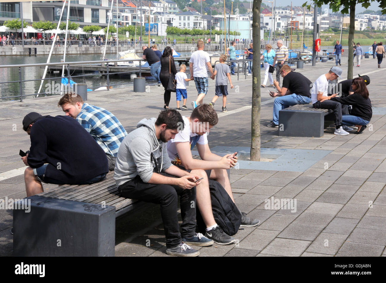 POKEMON GO, young people play the new Nintendo game Pokémon go on their smartphones on Lake Phoenix in Dortmund, Germany. The players try to catch in the real world virtual Pokemon monsters on to their smartphone devices. Stock Photo